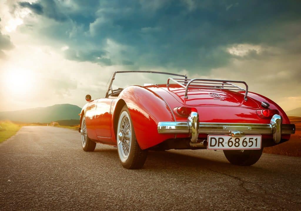 A red classic convertible faces down the open road.